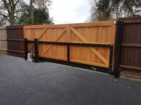 A wooden cantilever sliding gate with automation seen from the back